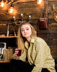 Girl in casual outfit sits in wooden vintage interior. Relax concept. Girl tomboy relax with glass...