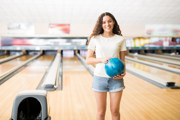 Girl With Ball Playing In Bowling Alley At Club