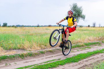 Cyclist riding on the rear wheel of the bicycle, active lifestyle.