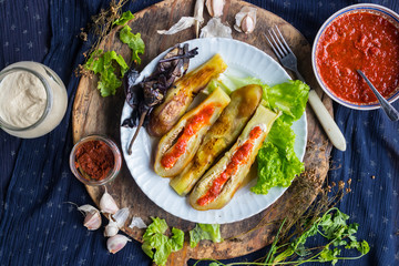 Roasted  grilled eggplants dressed with tomato garlic sauce, paprika, pepper and fresh salad leaves for lunch or dinner. Raw vegan vegetarian healthy food.