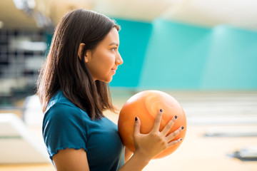 Girl Looking Away While Practicing Bowling In Club