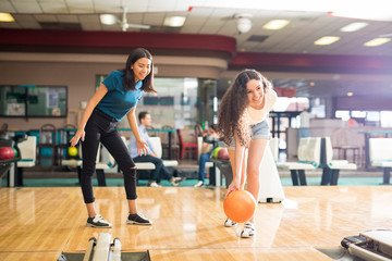 Girl Watching Friend Bowling In Club