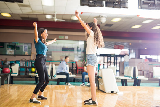 Girls Cheering While Bowling In Alley At Club