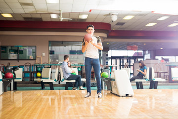 Boy About To Roll A Ball In Alley At Bowling