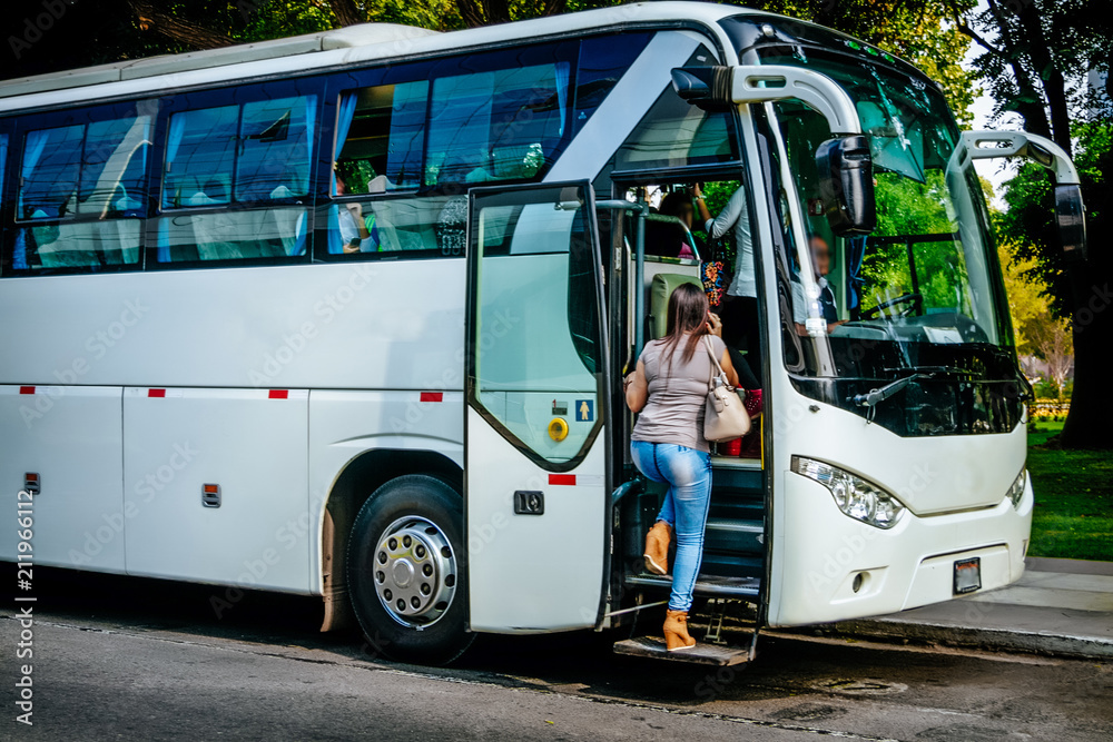 Wall mural transport, tourism, road trip and people concept - passenger boarding to travel in bus