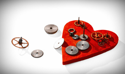 Gears on the background of the red heart. Selective focus.