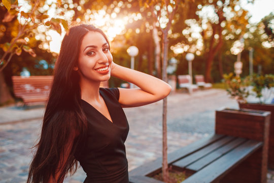 Stylish young business woman chilling in summer park. Fashionable outfit. Happy beautiful model smiling at camera