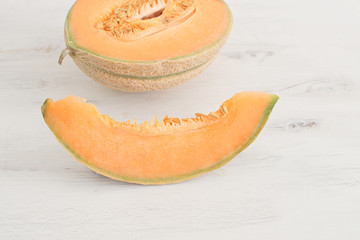 Summer harvest concept Fresh organic healthy fruit Sliced melon on white wooden background Copy space 