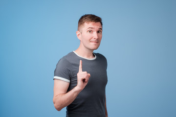 European man warning you to stop standing on blue background.
