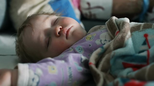 adorable blonde caucasian baby boy sleeping calm at home cute child covered with blanket having rest chubby cheeks closed eyes sweet face day light inside relaxation dream children healthcare serene