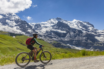 nice and ever young senior woman riding her e-mountainbike below the Eiger Northface near...