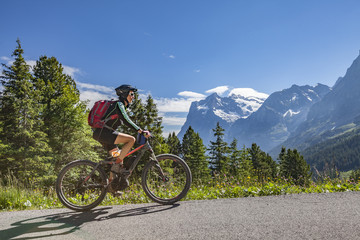 nice and ever young senior woman riding her e-mountainbike below the Eiger Northface near...