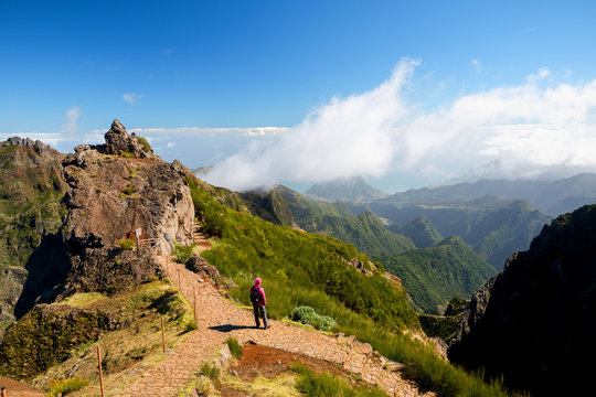 Woman alone looking at valley and mountains in sunny weather, Ninho da Manta, Pico do Areeiro, Madeira island, Portugal