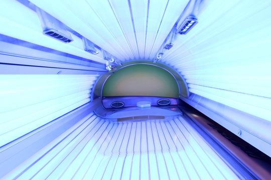 cabina de solarium con las luces ultravioletas encendidas