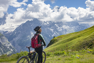 Fototapeta na wymiar nice and ever young senior woman riding her e-mountainbike below the Eiger Northface near Grindelwald and Wengen, Jungfrauregion, Switzerland