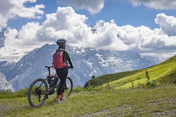 nice and ever young senior woman riding her e-mountainbike below the Eiger Northface near Grindelwald and Wengen, Jungfrauregion, Switzerland