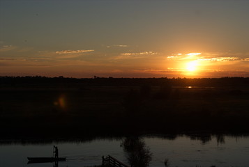 Astonishing sunset on the river with the man on his boat