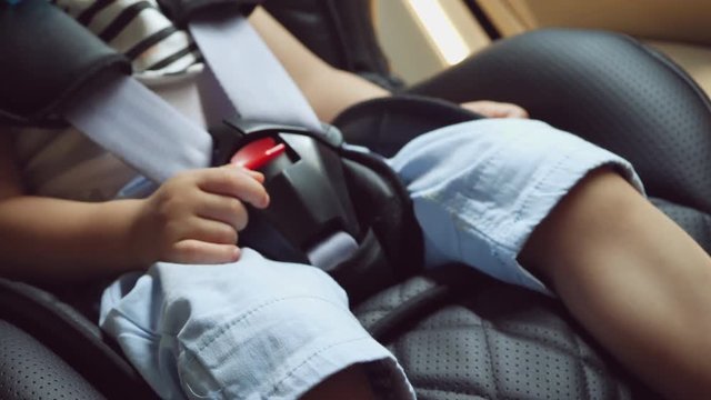 close-up safety belt lock of child sitting on car seat