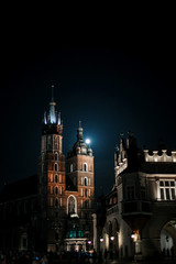 Old city center view St. Mary's Basilica, Square market in Krakow. Night Krakow. Moon over the church. Ancient building.