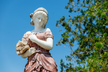 antique sculpture of a girl against the sky