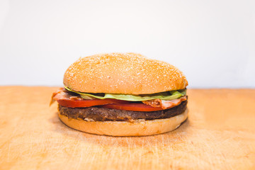 Hamburger on the orange wooden desk on white background