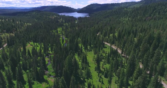Aerial Flyover of Creek Flowing Towards Mountain Lake