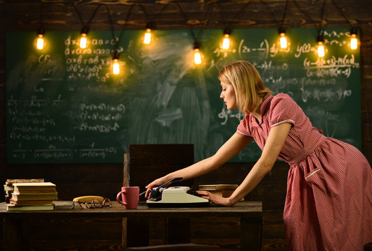 girl typing on a typewriter at school blackboard.