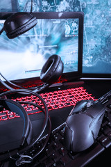 Gaming computer, laptop, keyboard, headphones and mouse headset for video gamer games on a dark background with copy space, concept of the latest gaming technology