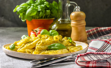penne pasta with pesto sauce in plate on a wooden background. selective focus