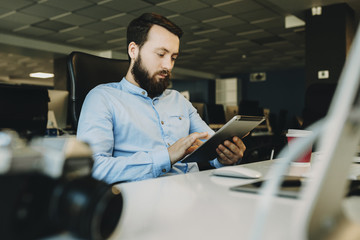 Man using tablet sitting in office