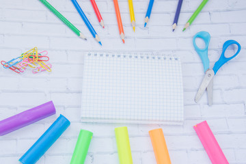 Color school supplies. Color pencils, markers, tassels, rubber, notebook, clips, multicolor plasticine, scissors