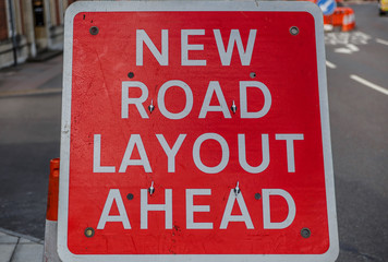 Obraz premium Poster in the middle of a street in England, indicating New road layout ahead