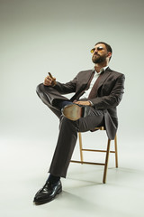 The barded man in a suit holding cigar