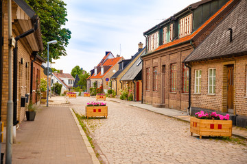 Fototapeta na wymiar Beautiful houses on Raavagen street with no people in evening in small town Raa - old fishing village located in southern Sweden south of Helsingborg