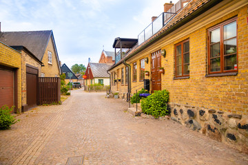 Fototapeta na wymiar Beautiful houses on Raavagen street with no people in evening in small town Raa - old fishing village located in southern Sweden south of Helsingborg