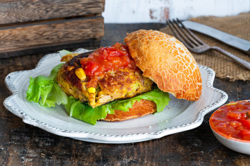 Tuna and sweetcorn burger with tomato salsa in a bun