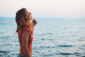 Young woman enjoying sunset by the sea