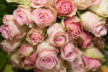 Wedding rings and bouquet of roses for bride