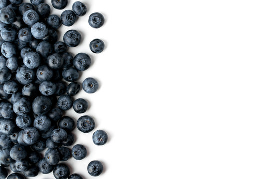 Blueberries scattered on a white background, top view.