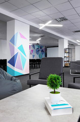 Conference hall.Coffe table with green plant and armchair on the first plan .Office.