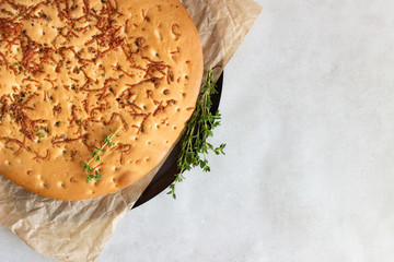 Traditional Italian focaccia with thyme on a light background.  Homemade flat bread focaccia
