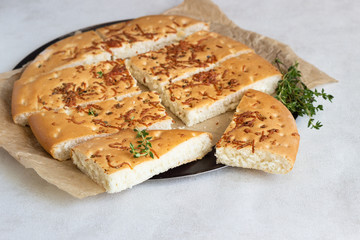 Traditional Italian focaccia with thyme on a light background.  Homemade flat bread focaccia