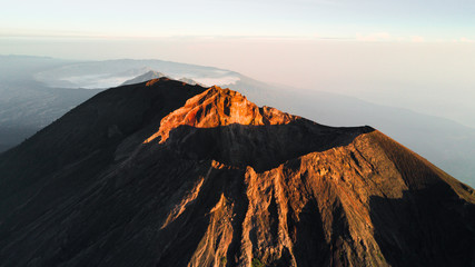 An aerial view of Mount Agung, the stratovolcano before eruption while sunrise shining to Crater Rim with Mount Batur in background from Bali, Indonesia