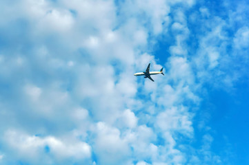 White clouds in the blue sky and passenger plane. Plane in the sky with clouds.