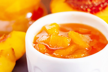 Nectarine jam in ramekin. Dark background. Selective focus. Close up.