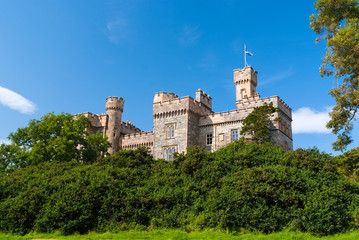 Summer vacation and wanderlust. Castle with green trees in Stornoway, United Kingdom. Lews Castle in garden on blue sky. Victorian style architecture and design. Landmark and attraction. © be free