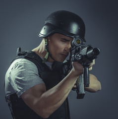 Security, paintball sport player wearing protective helmet aiming pistol ,black armor and machine gun over blue chroma background