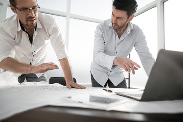 two architects use a laptop for work.