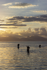 Swimmers at Sunset with Moorea in Background
