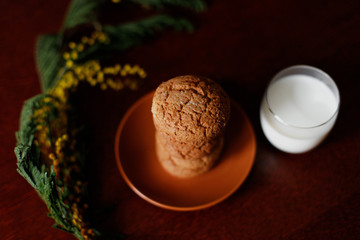 Oatmeal cookies and a glass of milk near the flowers.